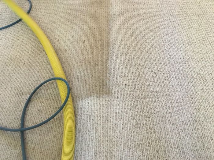Detail koberce, vyčištěný pruh vedle špinavého